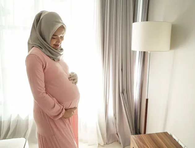 muslim-pregnant-woman-asian-home-looking-her-belly-rescaled